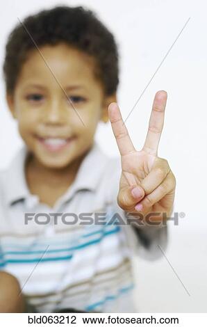 Stock Image - Mixed race boy gesturing the peace sign. Fotosearch