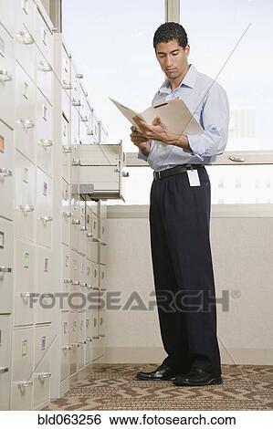 Stock Photograph - Mixed race businessman looking at files. Fotosearch