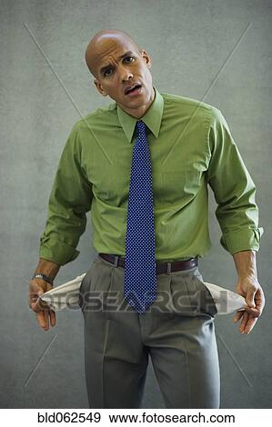 Mixed race businessman showing empty pockets View Large Photo Image Stock Photo - Mixed race businessman showing empty pockets. Fotosearch