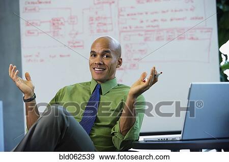 Mixed race businessman smiling and gesturing in office View Large Photo Image Stock Photo - Mixed race businessman smiling and gesturing in office. Fotosearch