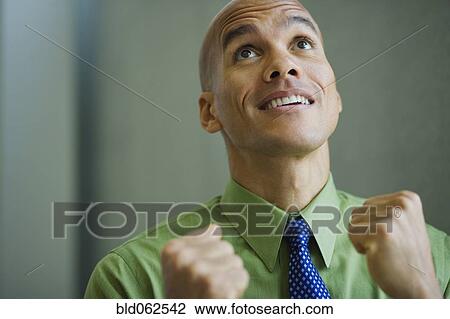 Mixed race businessman smiling with fists clenched View Large Photo Image Stock Image - Mixed race businessman smiling with fists clenched. Fotosearch