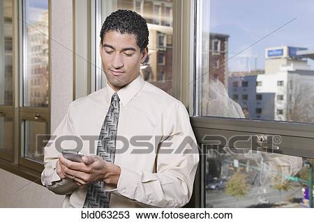 Mixed race businessman text messaging on cell phone View Large Photo Image Stock Image - Mixed race businessman text messaging on cell phone. Fotosearch
