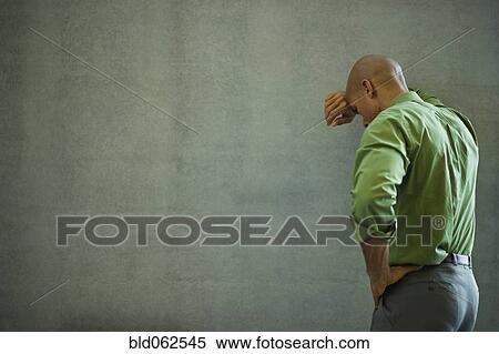 Stock Photography - Mixed race businessman with head in hands. Fotosearch