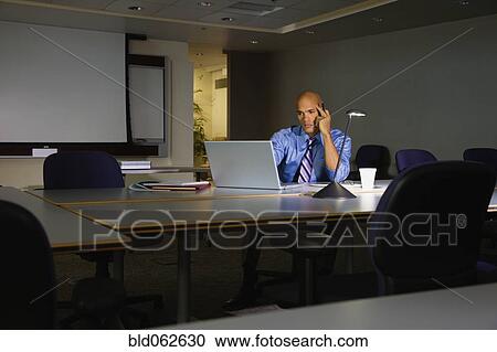 Stock Image - Mixed race businessman working on laptop in office. Fotosearch