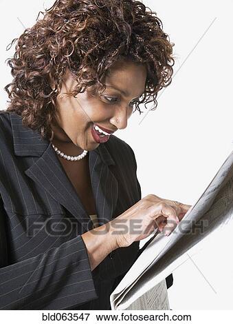 Stock Photo - Mixed race businesswoman pointing at newspaper. Fotosearch