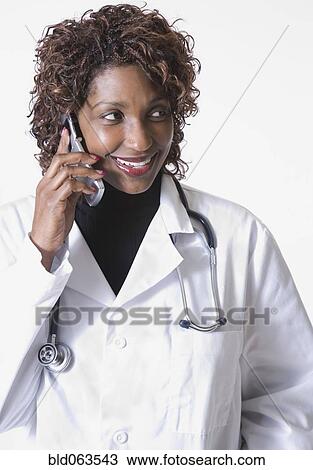 Mixed race doctor talking on cell phone View Large Photo Image Stock Image - Mixed race doctor talking on cell phone. Fotosearch