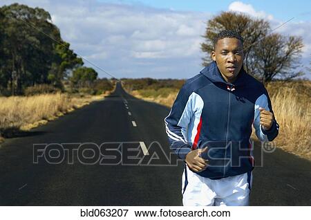 Mixed race man running on remote road View Large Photo Image Stock Photo - Mixed race man running on remote road. Fotosearch