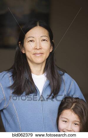 Stock Photo - Mixed race mother and daughter smiling. Fotosearch