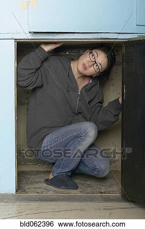 Mixed race woman crouching in small space View Large Photo Image Stock Photograph - Mixed race woman crouching in small space. Fotosearch