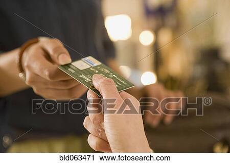 Mixed race woman handing credit card to cashier View Large Photo Image Stock Image - Mixed race woman handing credit card to cashier. Fotosearch