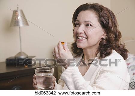 Mixed race woman taking vitamin View Large Photo Image Stock Image - Mixed race woman taking vitamin. Fotosearch