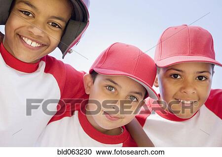 Stock Image - Multi-ethnic boys in baseball uniforms hugging. Fotosearch