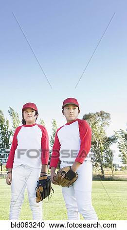 Multi-ethnic boys in baseball uniforms looking pensive View Large Photo Image Stock Image - Multi-ethnic boys in baseball uniforms looking pensive. Fotosearch