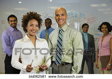 Stock Image - Multi-ethnic business people posing in office. Fotosearch