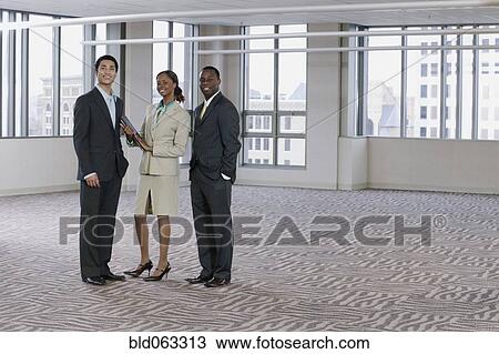 Multi-ethnic business people posing in empty building View Large Photo Image Stock Image - Multi-ethnic business people posing in empty building. Fotosearch