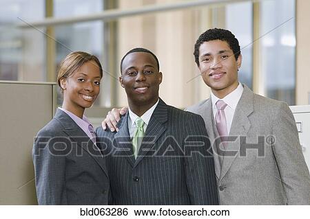 Stock Photograph - Multi-ethnic business people posing in office. Fotosearch