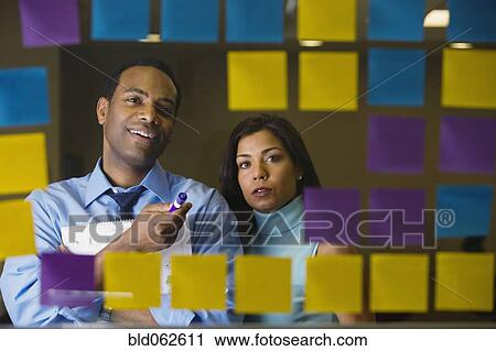 Multi-ethnic business people reviewing sticky notes View Large Photo Image Stock Image - Multi-ethnic business people reviewing sticky notes. Fotosearch