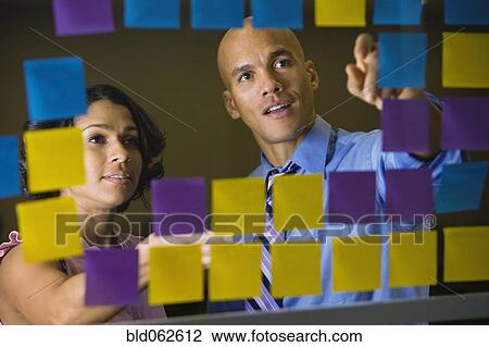 Multi-ethnic business people reviewing sticky notes View Large Photo Image Stock Image - Multi-ethnic business people reviewing sticky notes. Fotosearch