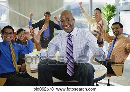Stock Photo - Multi-ethnic business people celebrating in office. Fotosearch