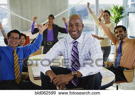 Stock Photo - Multi-ethnic business people celebrating in meeting. Fotosearch
