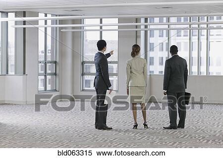 Multi-ethnic business people viewing empty building View Large Photo Image Stock Photography - Multi-ethnic business people viewing empty building. Fotosearch