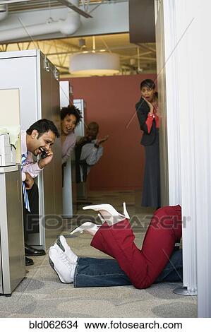 Picture - Multi-ethnic business people watching office romance. Fotosearch