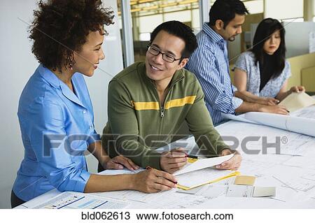 Stock Image - Multi-ethnic business people working in office. Fotosearch