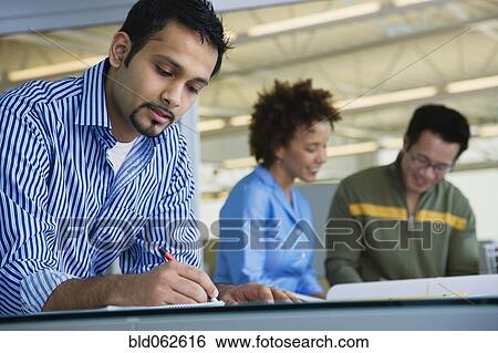 Stock Photograph - Multi-ethnic business people working in office. Fotosearch