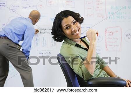 Multi-ethnic business people working on whiteboard View Large Photo Image Stock Photo - Multi-ethnic business people working on whiteboard . Fotosearch