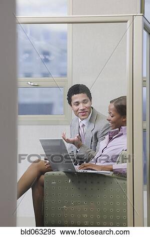 Stock Photography - Multi-ethnic business people working on laptop in office. Fotosearch