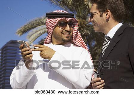 Stock Image - Multi-ethnic businessmen holding cell phones. Fotosearch