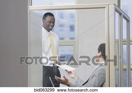 Multi-ethnic businessmen holding paperwork in office View Large Photo Image Stock Photo - Multi-ethnic businessmen holding paperwork in office. Fotosearch
