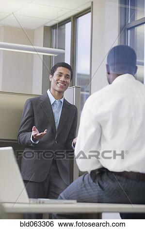 Stock Photograph - Multi-ethnic businessmen meeting in office. Fotosearch