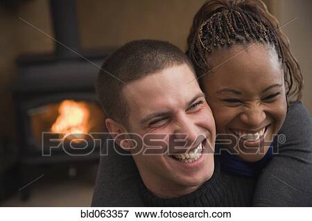 Multi-ethnic couple hugging and laughing View Large Photo Image Stock Photo - Multi-ethnic couple hugging and laughing. Fotosearch