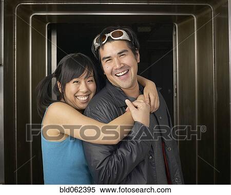 Stock Photography - Multi-ethnic couple hugging in doorway. Fotosearch