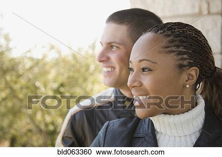 Multi-ethnic couple looking at view on balcony View Large Photo Image Stock Image - Multi-ethnic couple looking at view on balcony. Fotosearch