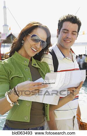Stock Image - Multi-ethnic couple viewing map. Fotosearch