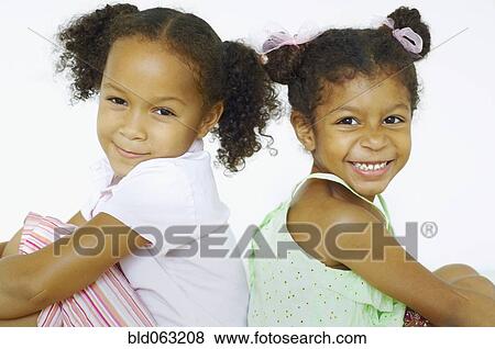 Multi-ethnic girls sitting back to back View Large Photo Image Stock Photo - Multi-ethnic girls sitting back to back. Fotosearch