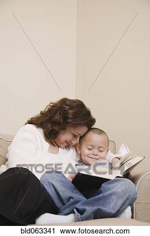 Stock Image - Multi-ethnic grandmother and grandson reading book. Fotosearch