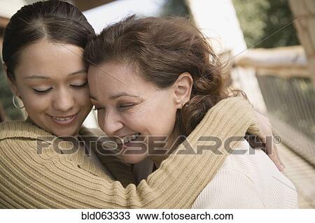Stock Image - Multi-ethnic mother and daughter hugging. Fotosearch