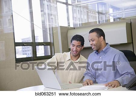 Two businessmen working in office View Large Photo Image Stock Image - Two businessmen working in office. Fotosearch