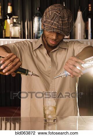 African bartender pouring a mixed drink View Large Photo Image Stock Image - African bartender pouring a mixed drink. Fotosearch