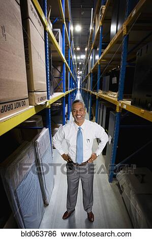Stock Photograph - African manager working in warehouse. Fotosearch