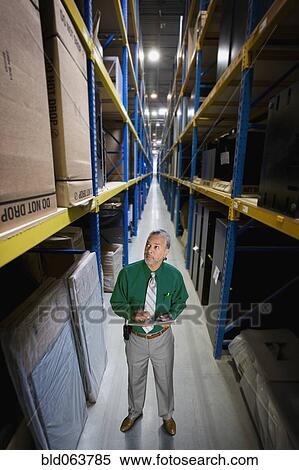 Stock Photography - African manager working in warehouse. Fotosearch