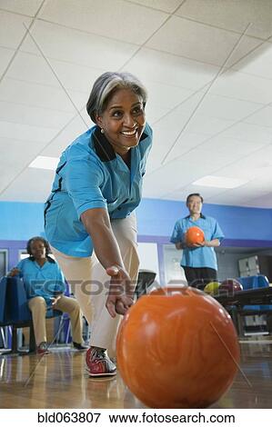 Stock Photo - African woman bowling for bowling league. Fotosearch