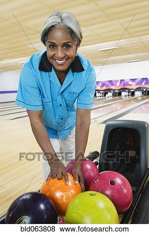 Stock Photo - African woman choosing bowling ball. Fotosearch