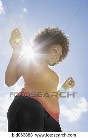 Stock Image - African woman dancing outdoors. Fotosearch
