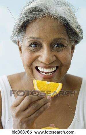 African woman eating orange slice View Large Photo Image Stock Photography - African woman eating orange slice. Fotosearch