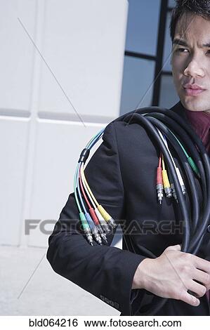 Asian businessman holding computer cable outdoors View Large Photo Image Stock Photograph - Asian businessman holding computer cable outdoors. Fotosearch