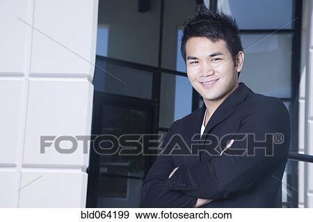 Asian businessman outside office building View Large Photo Image Stock Photo - Asian businessman outside office building. Fotosearch
